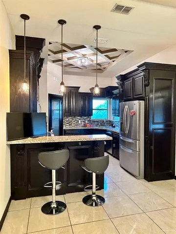 a kitchen with a sink stainless steel appliances a refrigerator and a counter