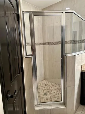 a bathroom with a shower and a glass door