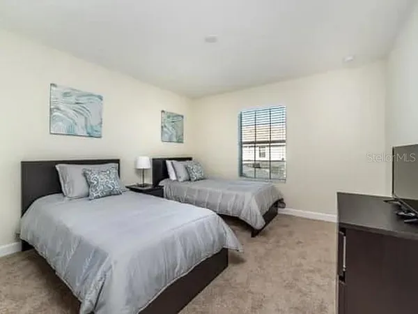 a bedroom with two beds and a desk