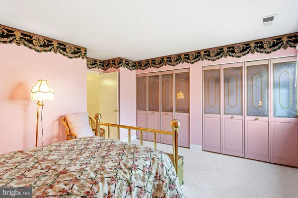 a bedroom with a bed and a large mirror