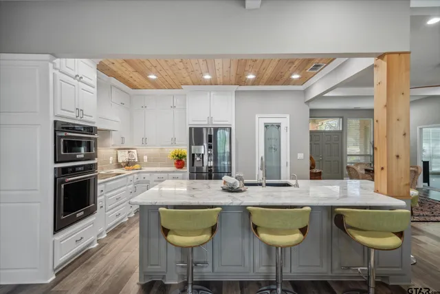 a kitchen with stainless steel appliances granite countertop a stove a sink and a refrigerator