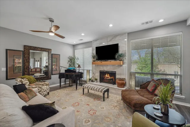 a living room with furniture a fireplace a flat screen tv and potted plant