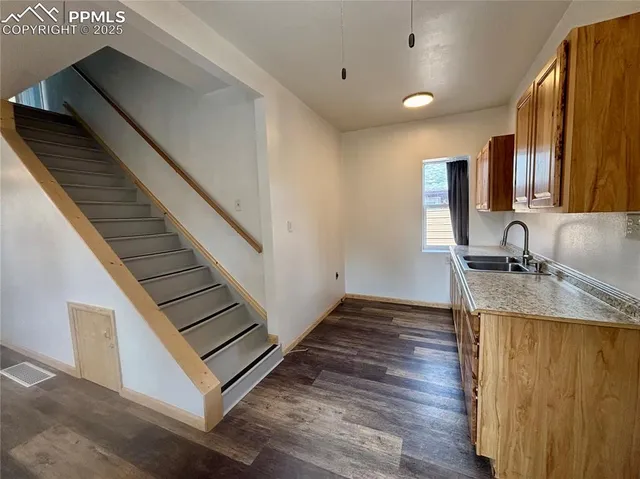 a view of a kitchen with kitchen island a sink wooden floor and a window