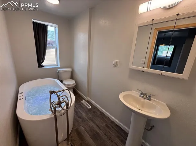 a bathroom with a sink a toilet and mirror