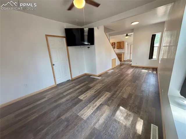 a view of a livingroom with wooden floor and a ceiling fan