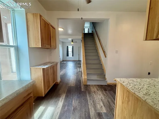a view of a kitchen with wooden floor and staircase
