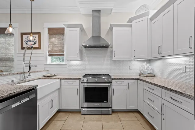 a kitchen with stainless steel appliances granite countertop white cabinets and a sink