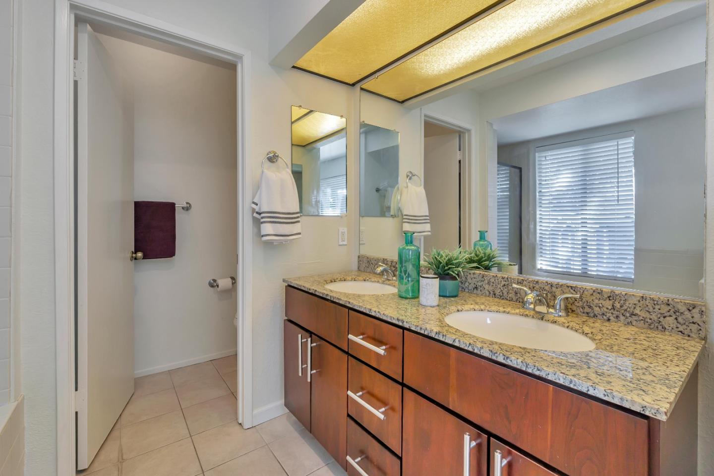 1677 Geary Road Walnut Creek, CA 94597 - Photo 16 of 38 a bathroom with a granite countertop sink and a mirror
