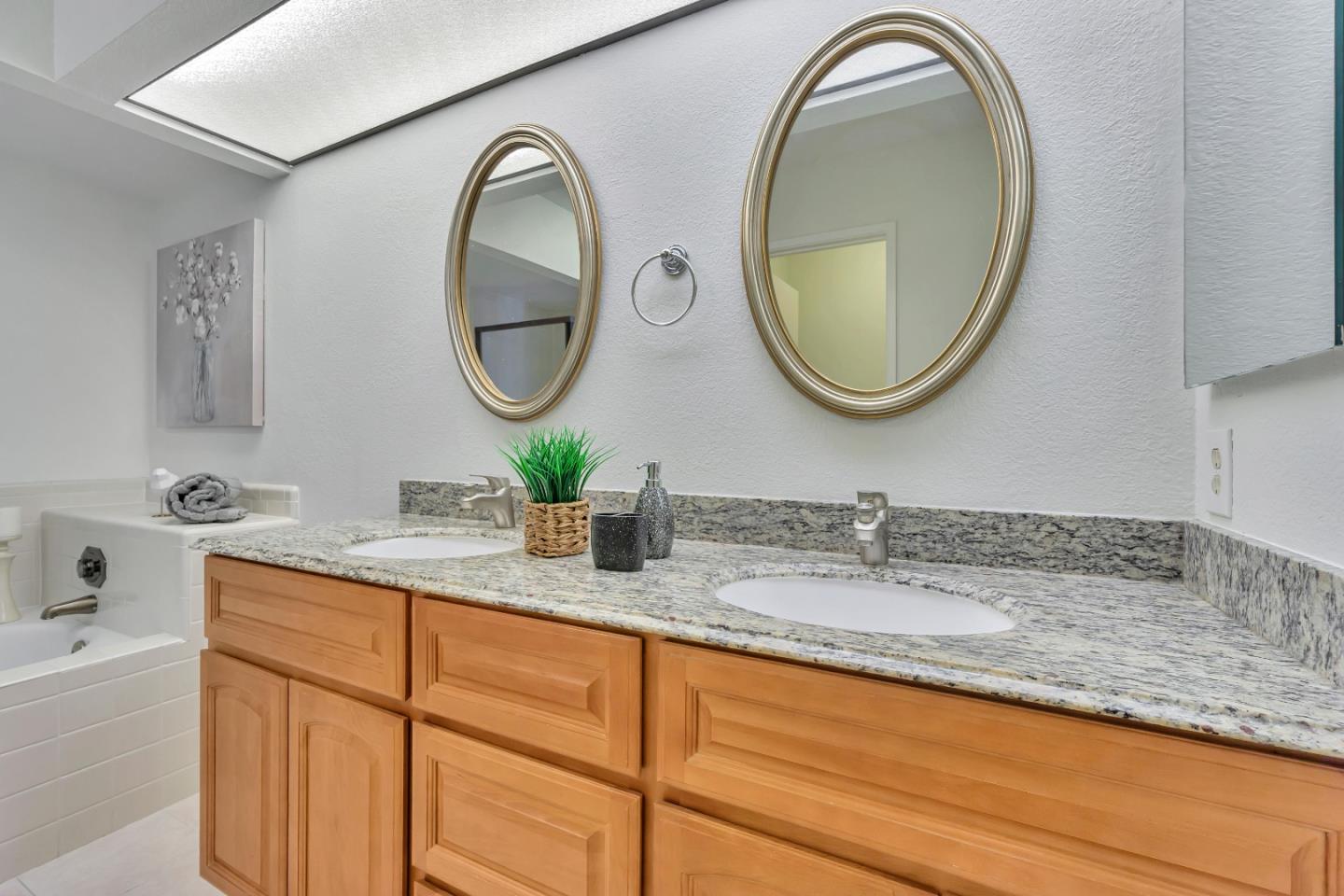 1677 Geary Road Walnut Creek, CA 94597 - Photo 24 of 38 a bathroom with a granite countertop double vanity sink and a mirror