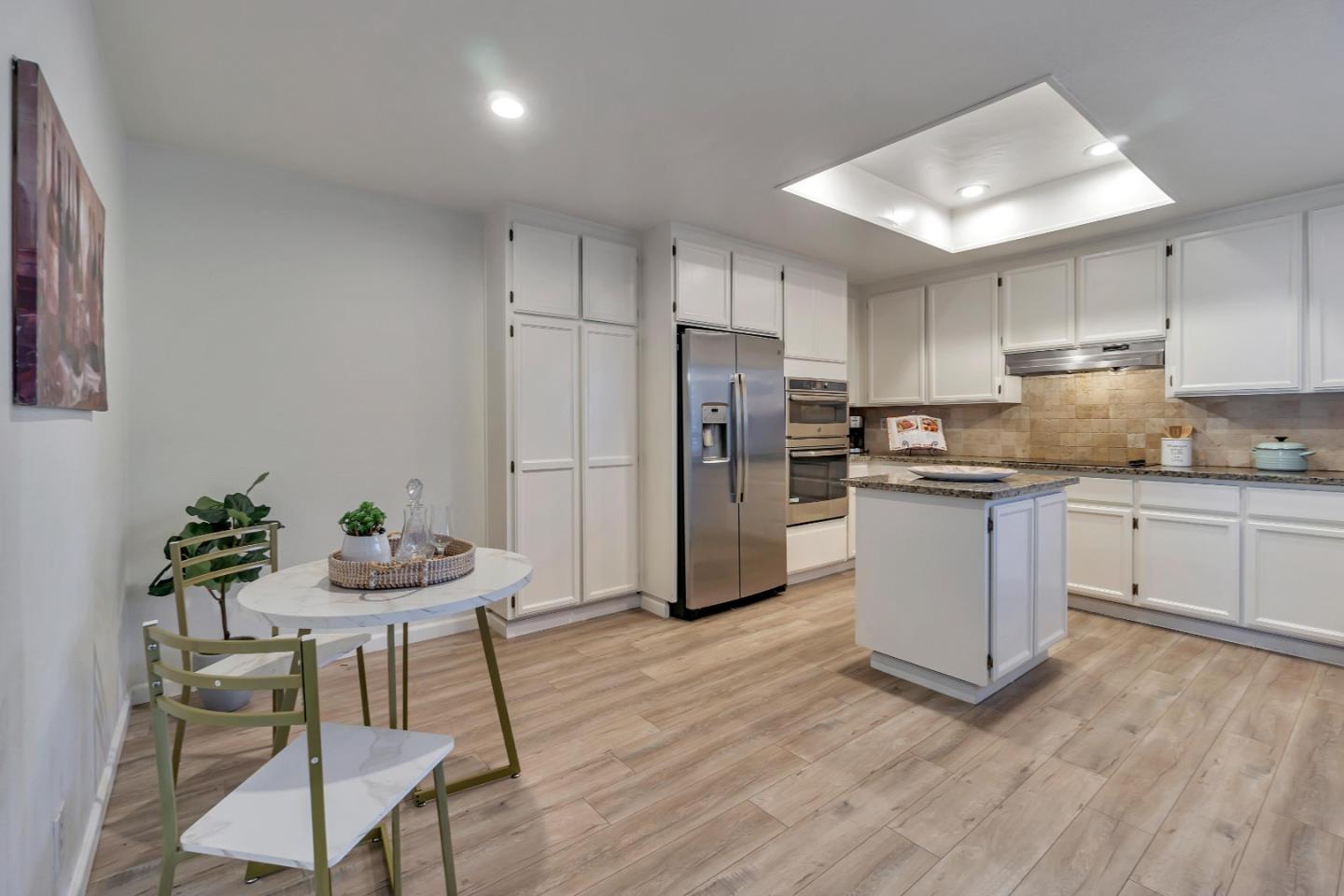 1677 Geary Road Walnut Creek, CA 94597 - Photo 6 of 38 a kitchen with stainless steel appliances a refrigerator a stove a sink dishwasher and a dining table with wooden floor