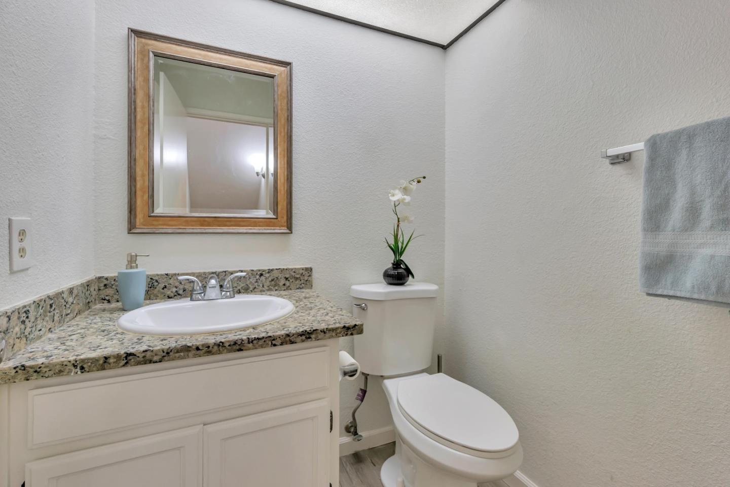 1677 Geary Road Walnut Creek, CA 94597 - Photo 9 of 38 a bathroom with a granite countertop toilet sink and mirror