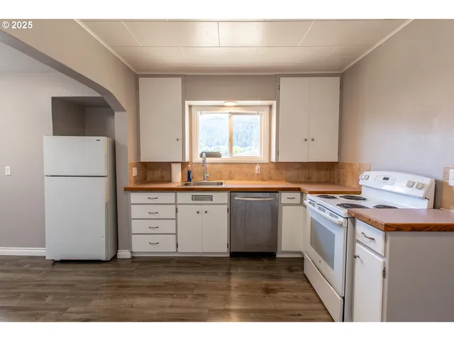 a kitchen with a refrigerator and white cabinets