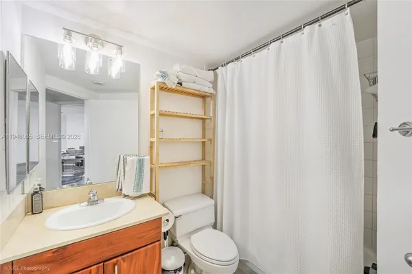 a bathroom with a sink a toilet and shower curtain