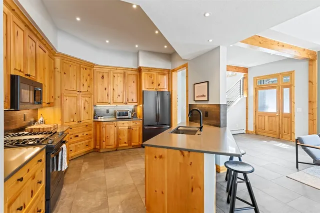 a kitchen with stainless steel appliances kitchen island granite countertop a stove top oven a sink and cabinets