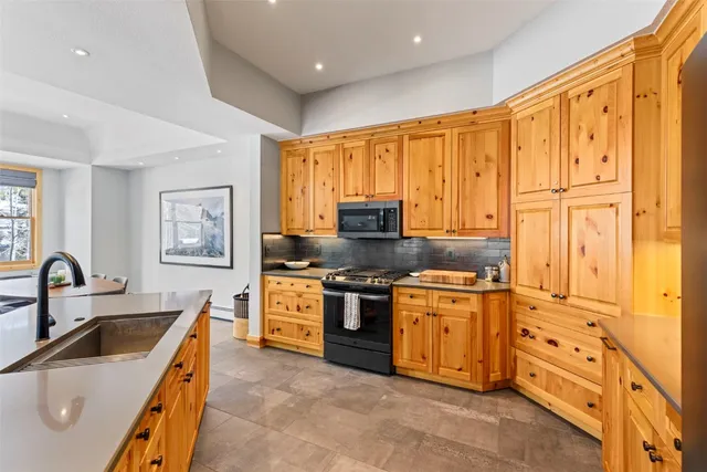 a kitchen with stainless steel appliances granite countertop a stove sink and cabinets