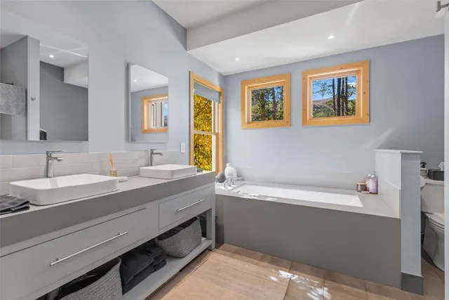 a bathroom with a tub sink and mirror