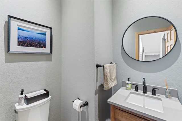 a bathroom with a toilet a sink and a mirror