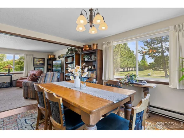 a dining room with wooden floor and large window