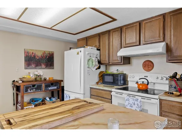 a kitchen with stainless steel appliances a stove a refrigerator and wooden cabinets
