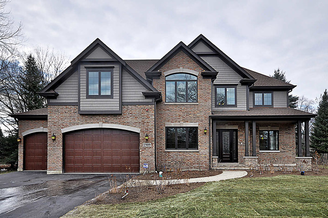 a front view of a house with yard and parking