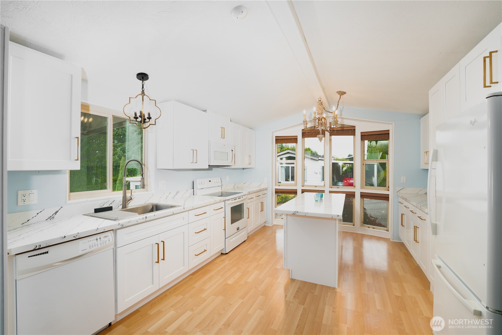 1415 84th Street Southeast, Unit 54 Everett, WA 98208 - Photo 2 of 19 a large white kitchen with kitchen island a large counter space a sink stainless steel appliances and cabinets