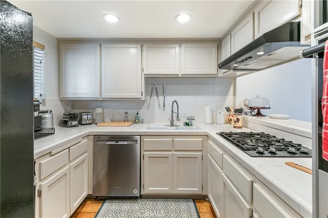 a kitchen with stainless steel appliances granite countertop a sink stove and cabinets