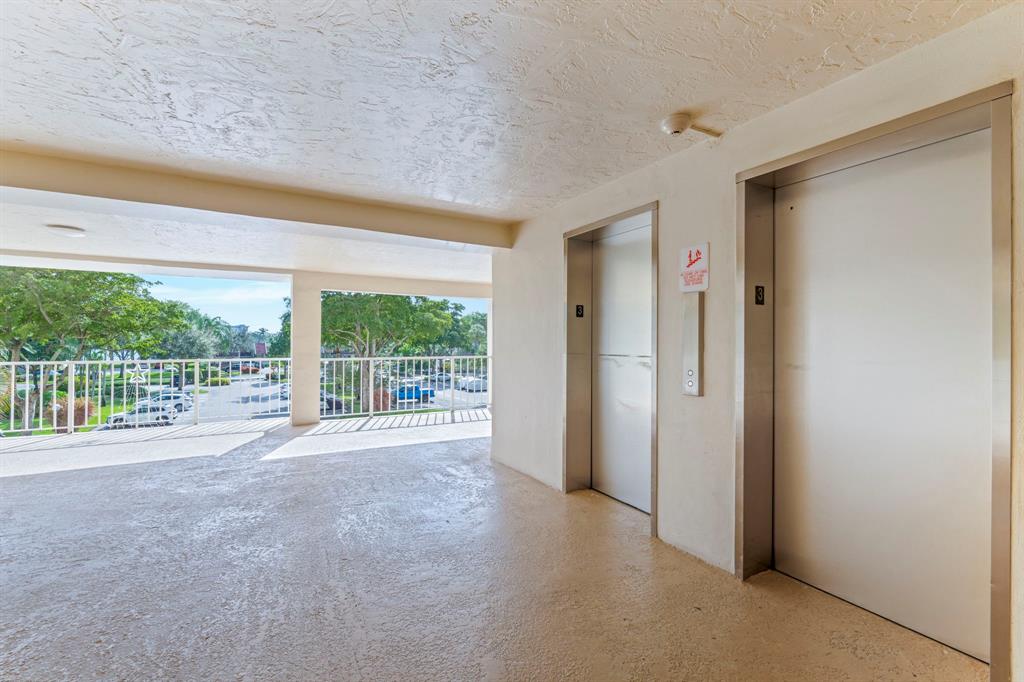 3090 North Course Drive, Unit 309 Pompano Beach, FL 33069 - Photo 20 of 21 a view of an empty room with wooden floor and a window