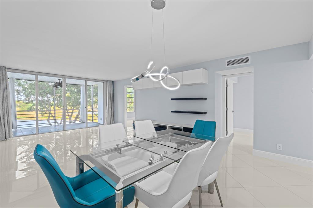 3090 North Course Drive, Unit 309 Pompano Beach, FL 33069 - Photo 3 of 21 a dining room with furniture and wooden floor