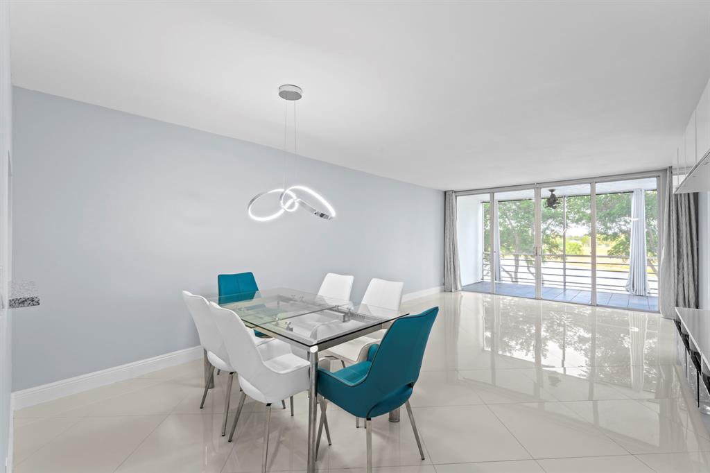 3090 North Course Drive, Unit 309 Pompano Beach, FL 33069 - Photo 6 of 21 a view of a dining room with furniture and a large window