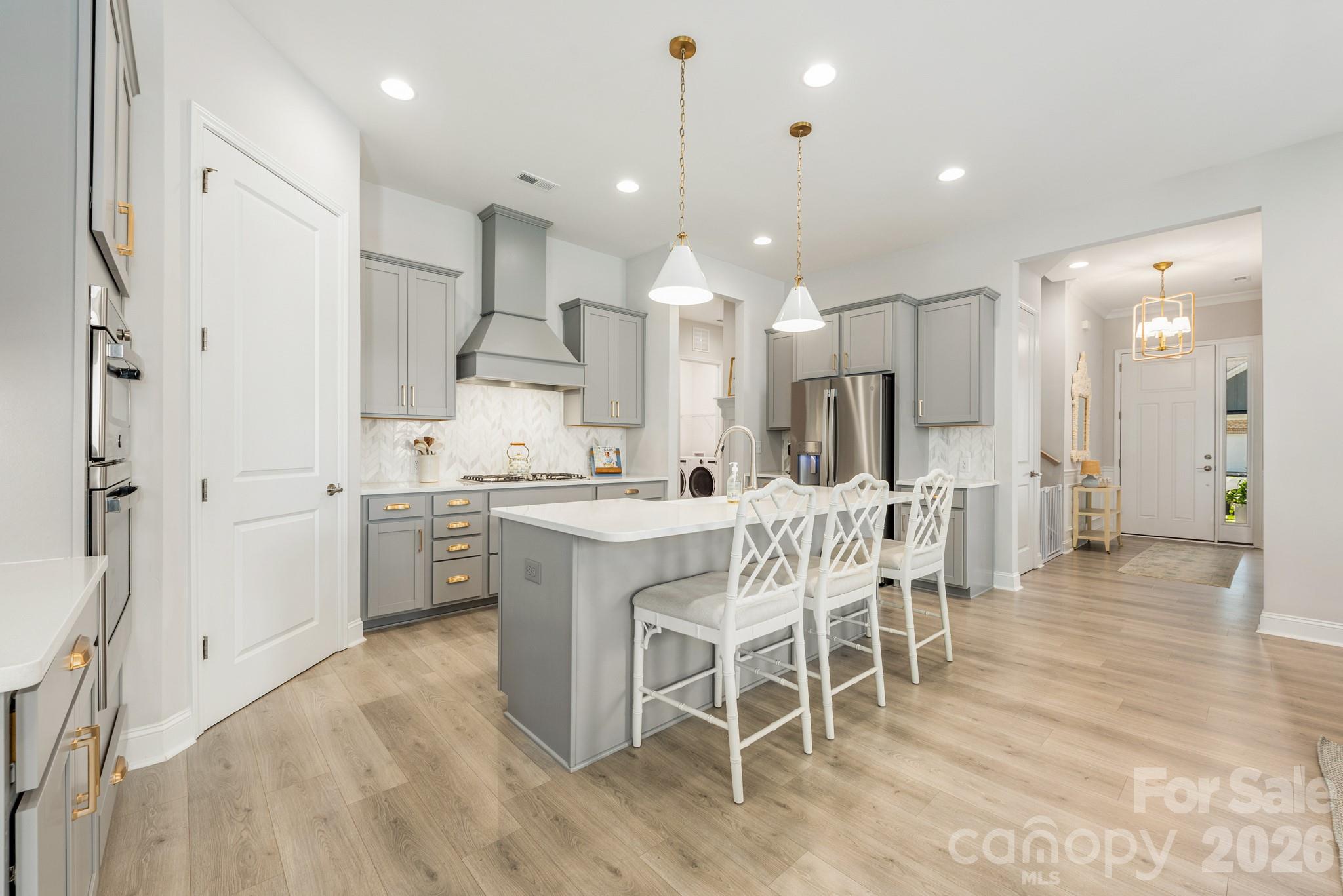 17210 Sand Bank Road Charlotte, NC 28278 - Photo 3 of 20 a kitchen with stainless steel appliances kitchen island granite countertop a table chairs sink and cabinets