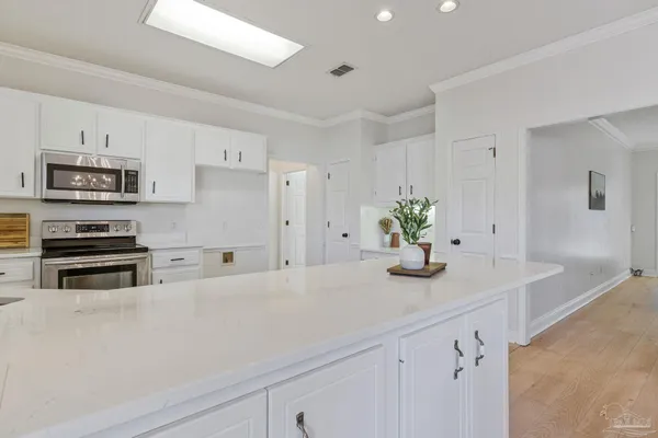 a kitchen with a refrigerator and white cabinets