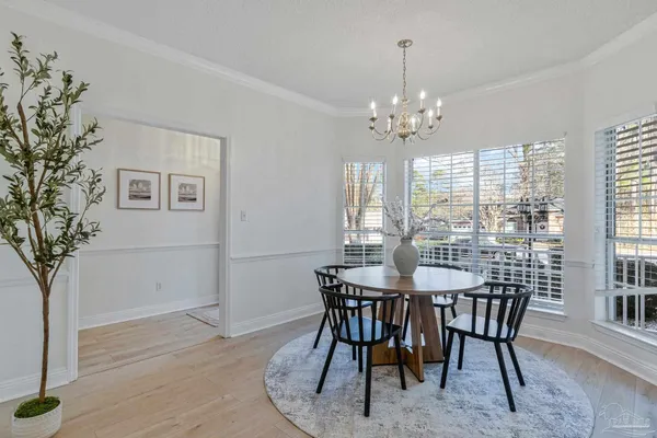 a kitchen with stainless steel appliances kitchen island granite countertop a dining table chairs and a refrigerator