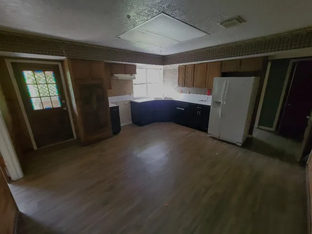 a view of empty room with wooden floor and window