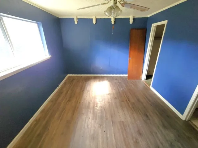 a view of empty room with window and wooden floor