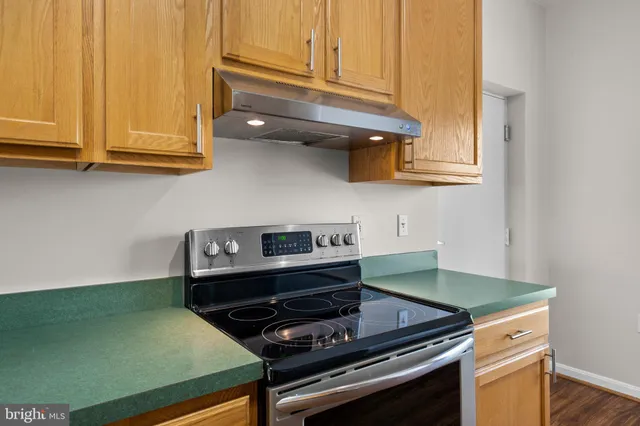a kitchen with wooden cabinets and a stove top oven