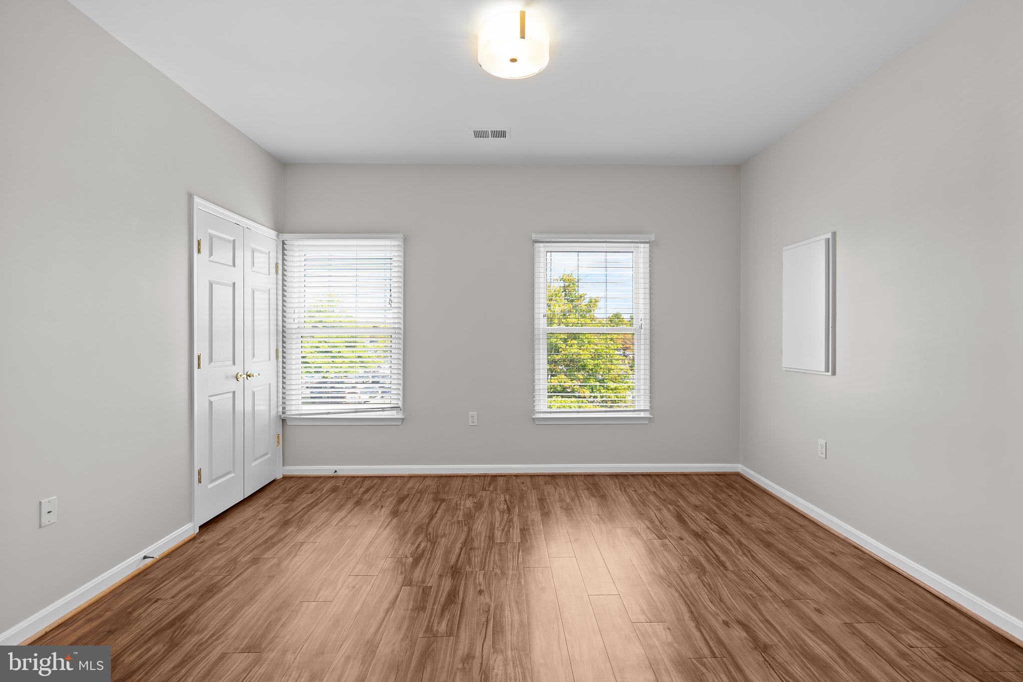 402 Main Street, Unit 300 Gaithersburg, MD 20878 - Photo 13 of 30 an empty room with wooden floor and windows