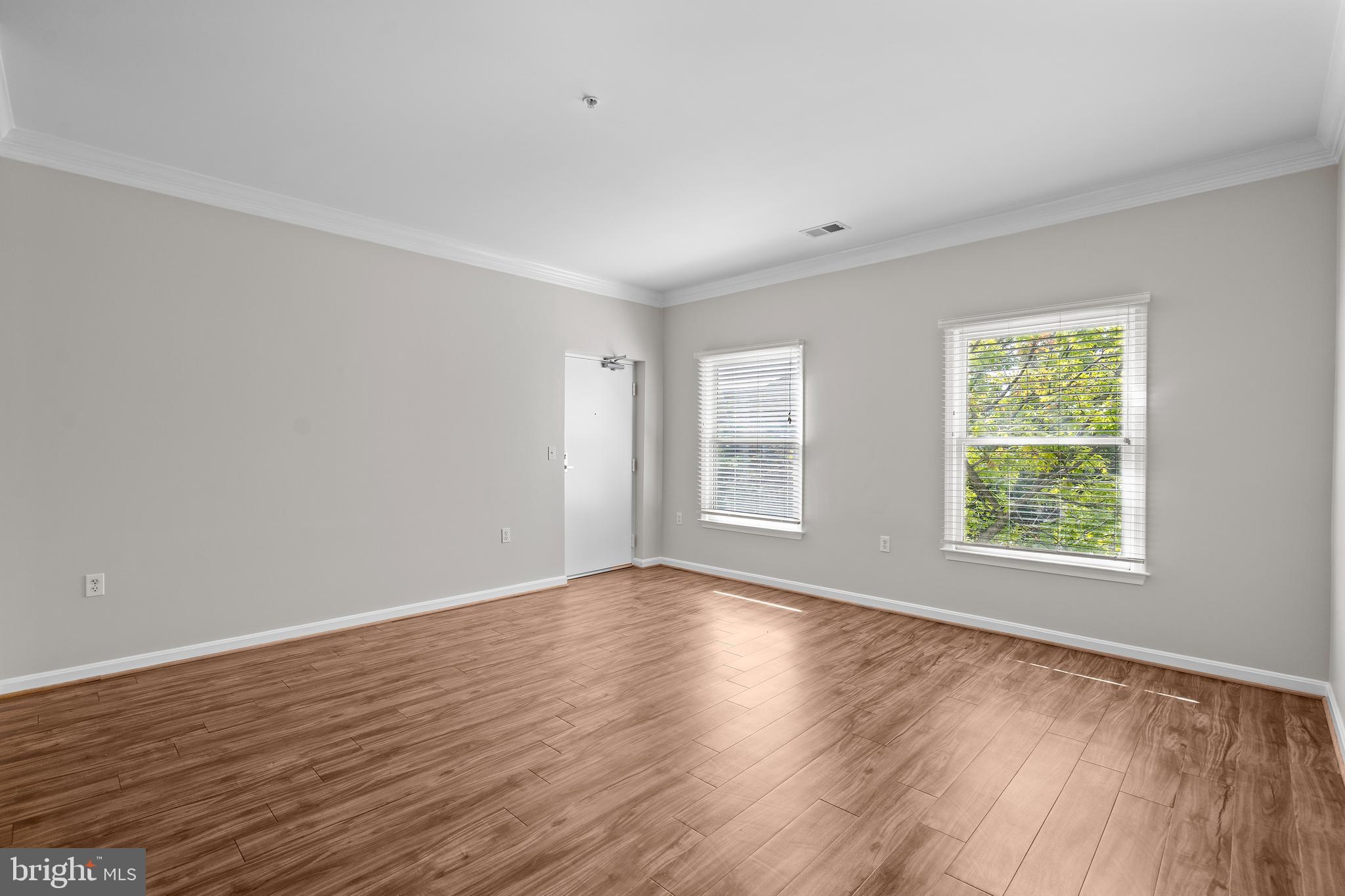 402 Main Street, Unit 300 Gaithersburg, MD 20878 - Photo 4 of 30 a view of an empty room with wooden floor and a window