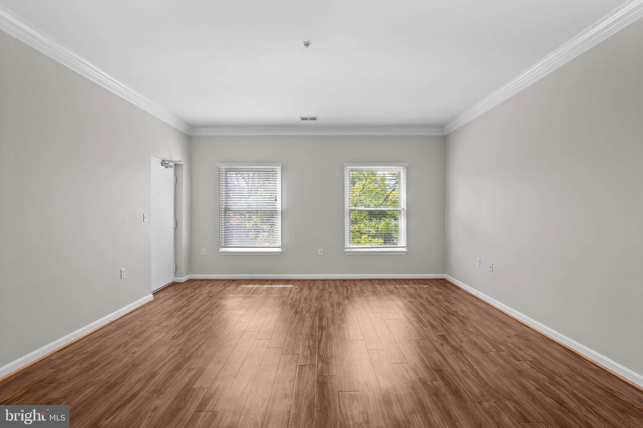 402 Main Street, Unit 300 Gaithersburg, MD 20878 - Photo 7 of 30 an empty room with wooden floor and windows