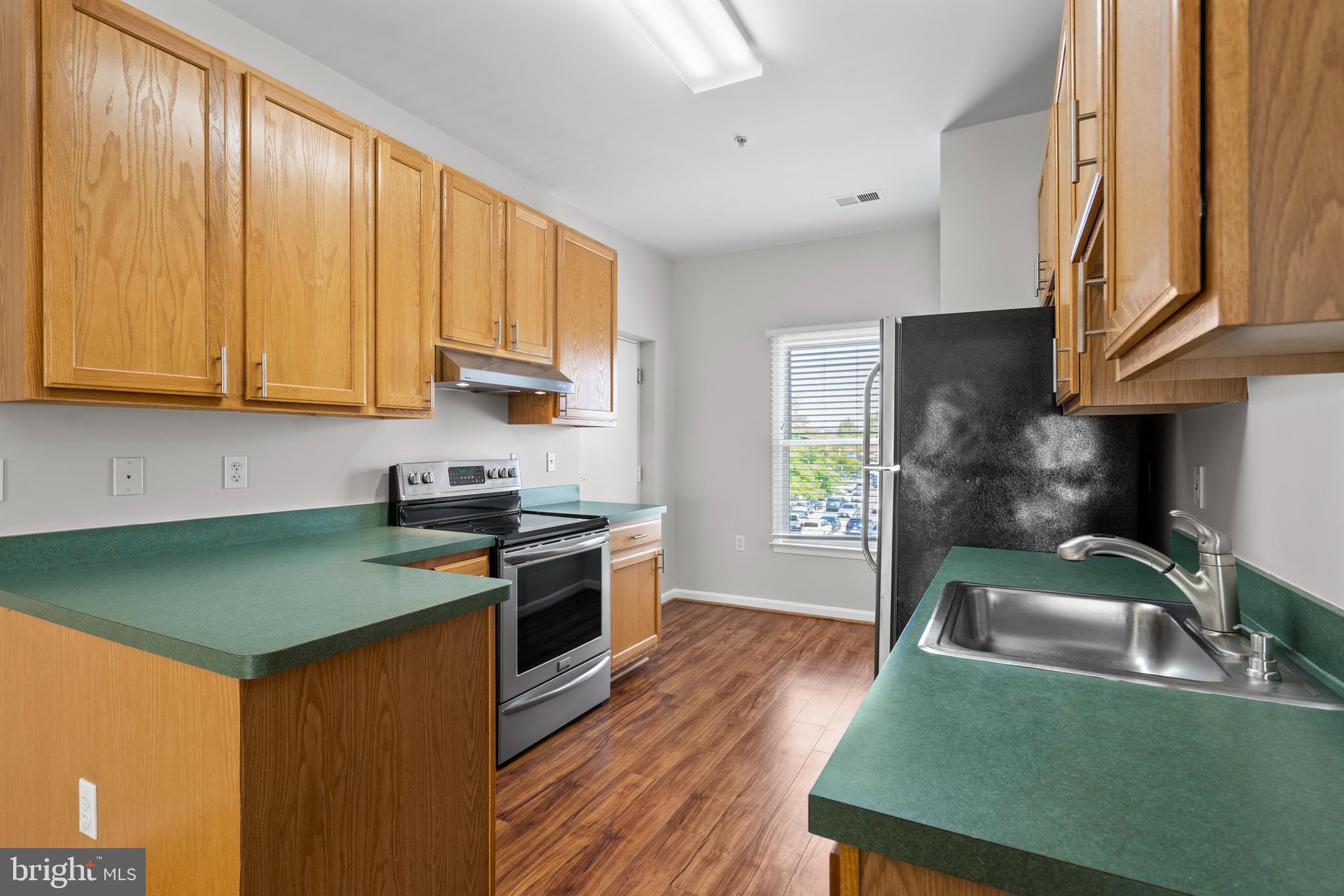 402 Main Street, Unit 300 Gaithersburg, MD 20878 - Photo 8 of 30 a kitchen with granite countertop a sink stove and cabinets