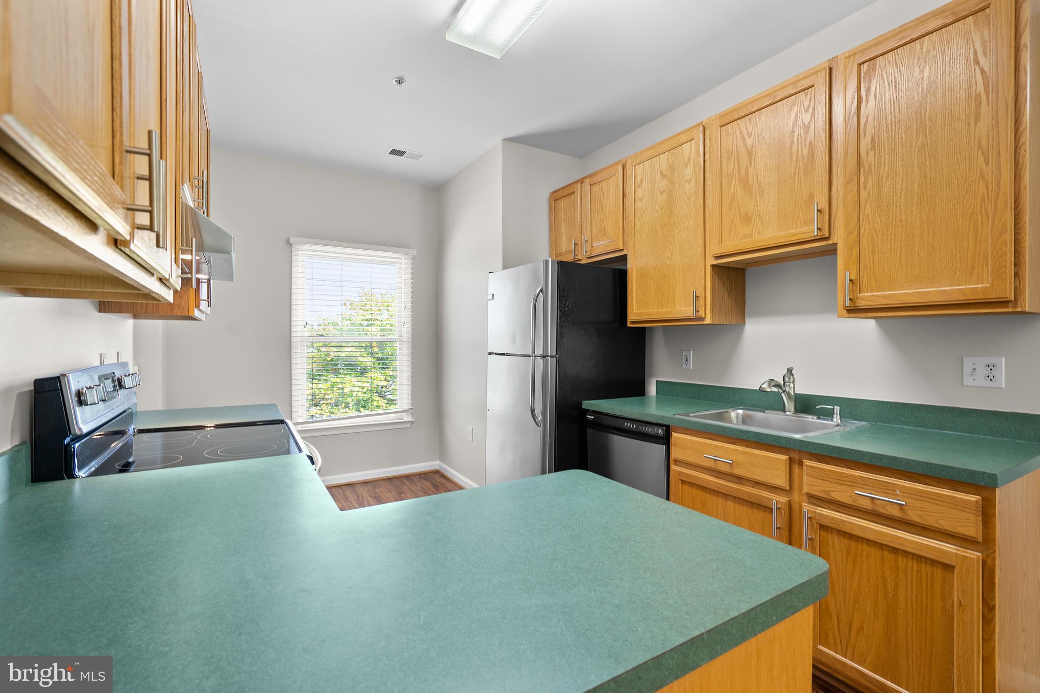 402 Main Street, Unit 300 Gaithersburg, MD 20878 - Photo 10 of 30 a kitchen with stainless steel appliances granite countertop a sink stove and refrigerator