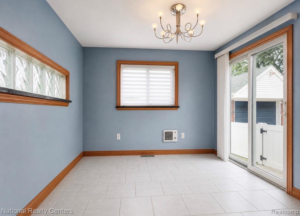 7285 Helen Street Center Line, MI 48015 - Photo 12 of 32 Spacious room featuring light tile flooring, wood-framed windows, and a glass block privacy window