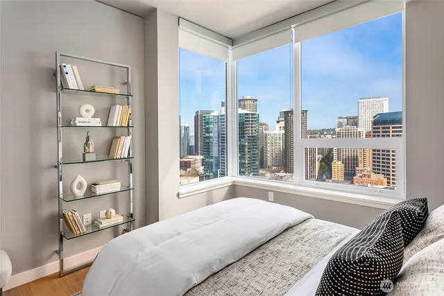 a bedroom with a large window and a bed