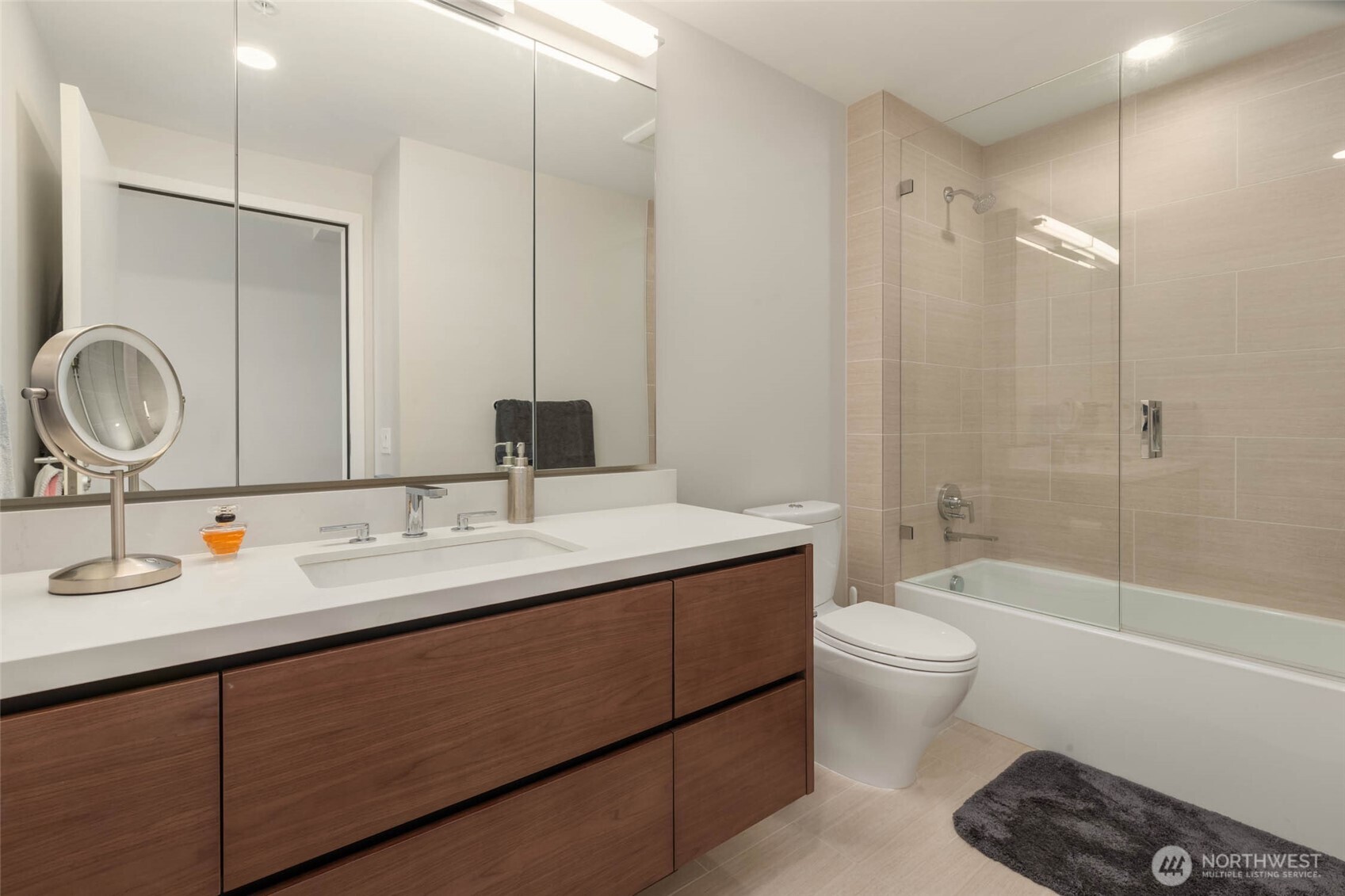 121 Stewart Street, Unit 1701 Seattle, WA 98101 - Photo 16 of 32 a bathroom with a double vanity sink toilet mirror and bathtub