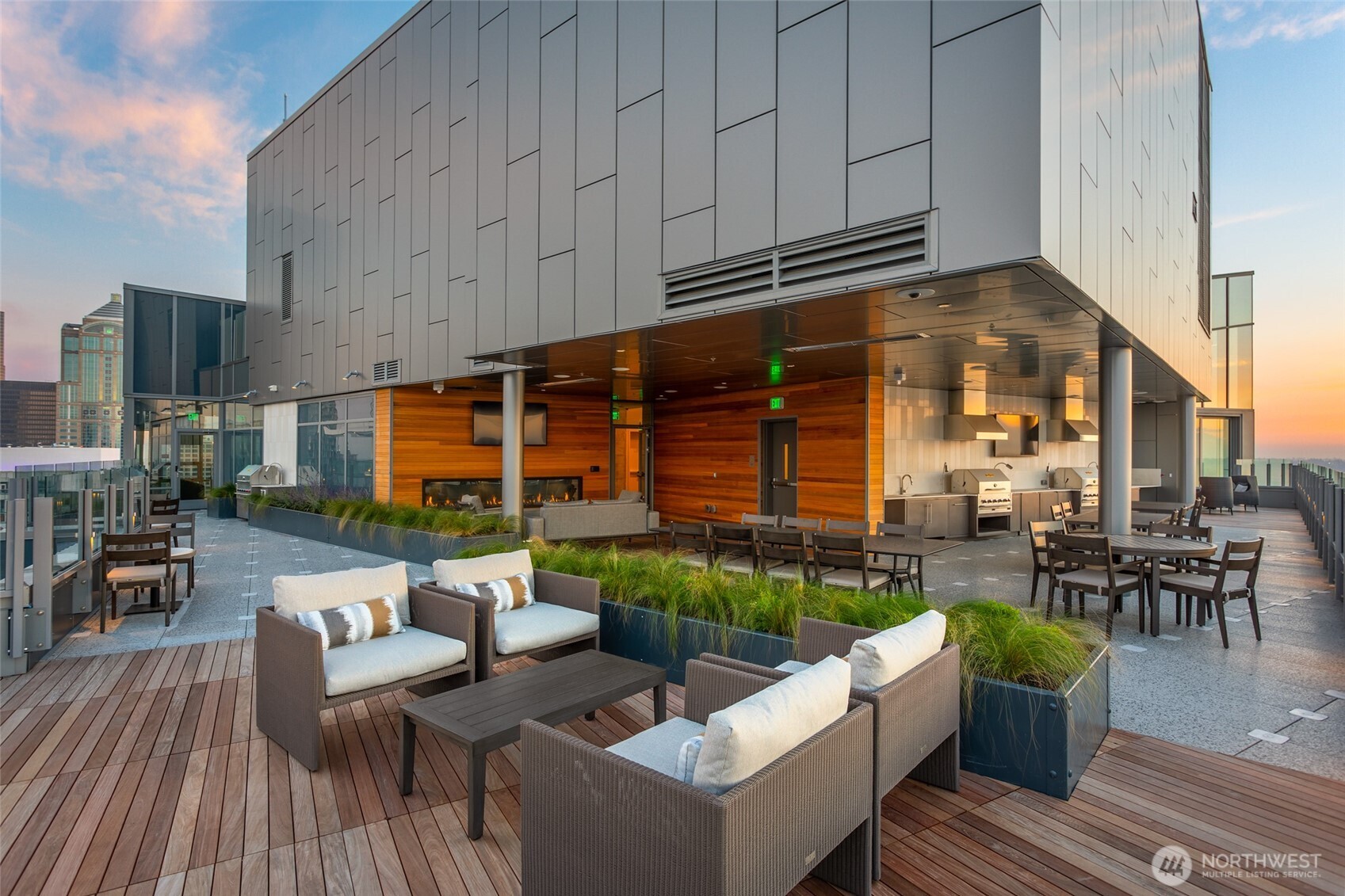 121 Stewart Street, Unit 1701 Seattle, WA 98101 - Photo 27 of 32 a view of a patio with couches chairs dining table and chairs with wooden floor