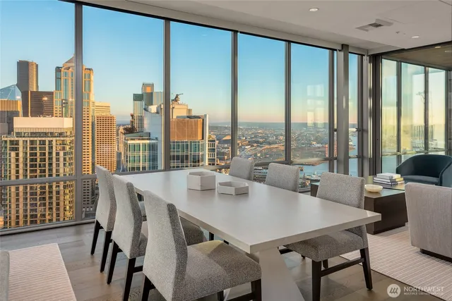 a kitchen with stainless steel appliances a table chairs in it and wooden floors
