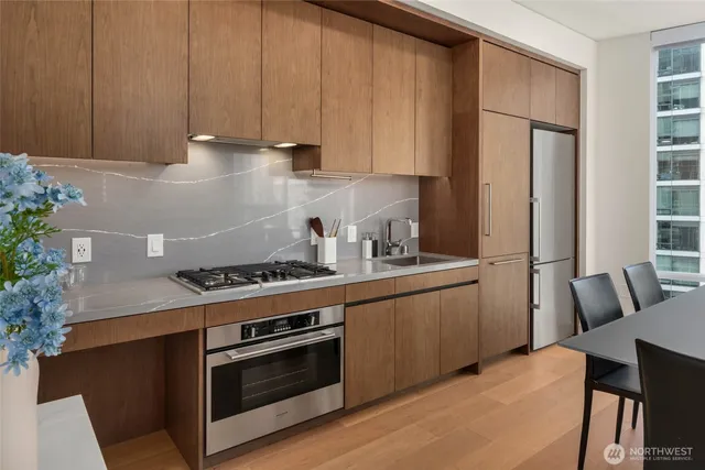 a kitchen with stainless steel appliances granite countertop a stove a refrigerator and a microwave