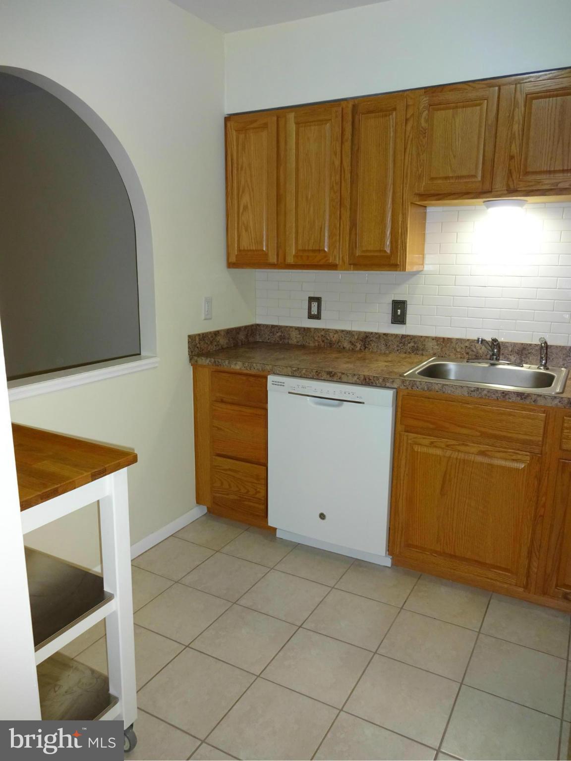 521 Epsom Road, Unit 2B Baltimore, MD 21286 - Photo 3 of 14 a kitchen with a sink a stove and cabinets