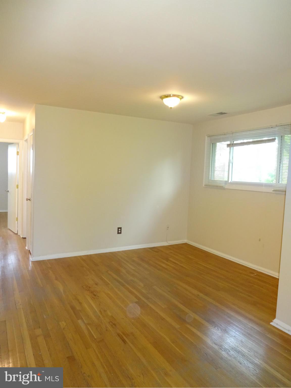 521 Epsom Road, Unit 2B Baltimore, MD 21286 - Photo 4 of 14 an empty room with wooden floor and windows
