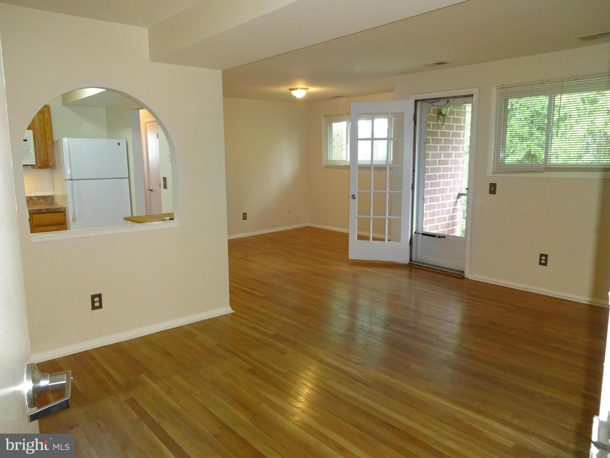 521 Epsom Road, Unit 2B Baltimore, MD 21286 - Photo 5 of 14 an empty room with wooden floor and windows