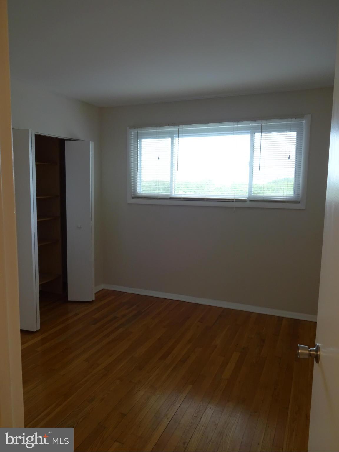 521 Epsom Road, Unit 2B Baltimore, MD 21286 - Photo 7 of 14 an empty room with wooden floor and windows